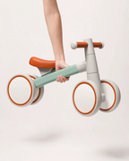 Montessori balance bike lifted easily with one hand, showing its lightweight aluminum frame