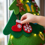 Child's hand placing a red felt bauble on thick felt