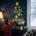 Felt Christmas tree on a blue wall, toddler adding a reindeer