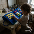 Blue felt busy book open at the kitchen table