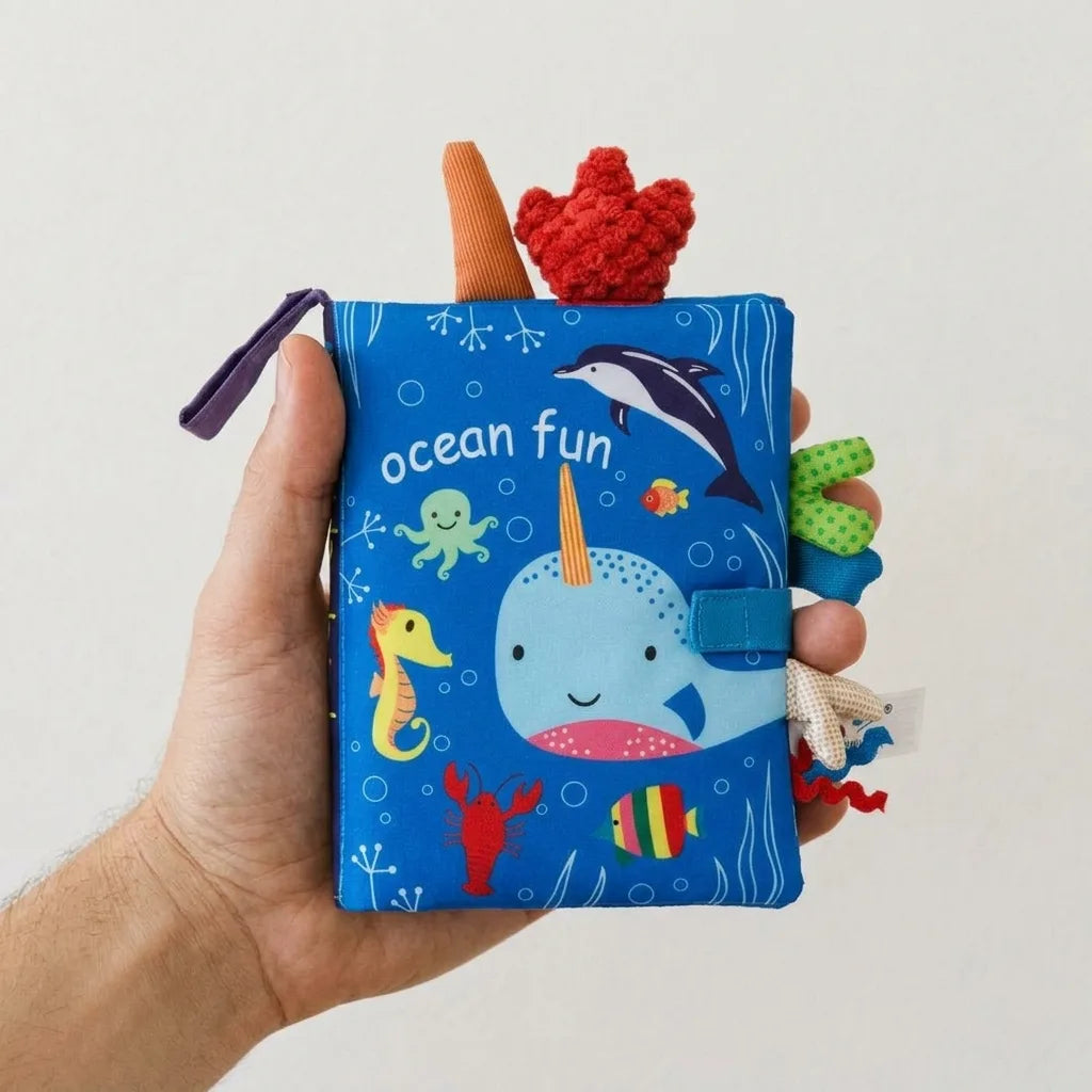 Montessori soft cloth books for babies held in an adult hand for scale