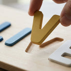 Thick painted wooden letter lifted from its routed slot