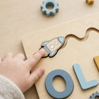Child finger sliding the rocket piece along its groove