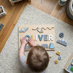 Toddler fitting a painted letter into the name puzzle