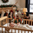Baby lying in the crib looking up at the Reindeer & Trees felt mobile