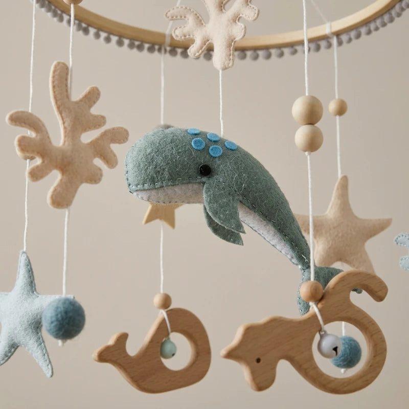 Close-up of the hand-stitched wool felt on the Sage Whale crib mobile