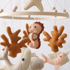 Close-up of the hand-stitched wool felt on the Terracotta Coral crib mobile