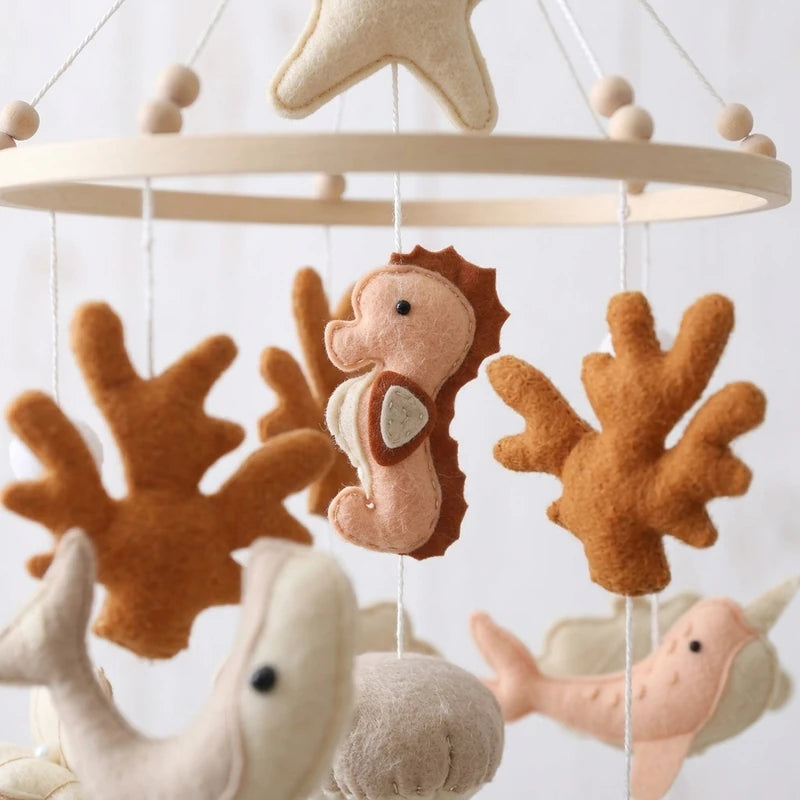 Close-up of the hand-stitched wool felt on the Terracotta Coral crib mobile