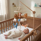 Baby lying in the crib looking up at the Terracotta Coral felt mobile