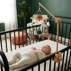 Baby lying in the crib looking up at the Cactus Savanna felt mobile
