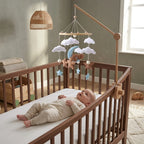Baby lying in the crib looking up at the Blue Moon Bear felt mobile