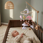 Baby lying in the crib looking up at the Pink Cloud Bear felt mobile