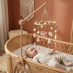 Baby lying in the crib looking up at the Wool Ball Bunnies felt mobile