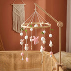 Wooden baby crib mobile, Wool Ball Bunnies design, clamped on a crib rail in a woodland nursery