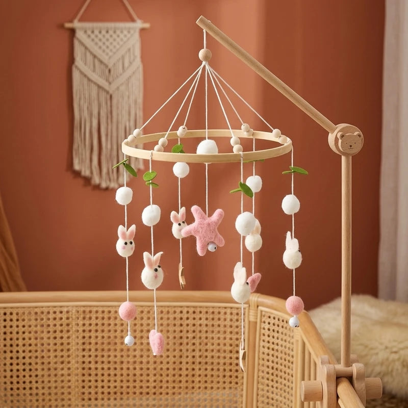 Wooden baby crib mobile, Wool Ball Bunnies design, clamped on a crib rail in a woodland nursery